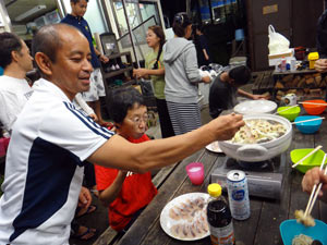 鍋に手を出す車田さん